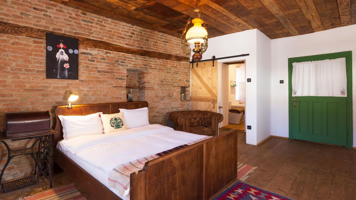 King bed against the old brick wall, under an oil lamp