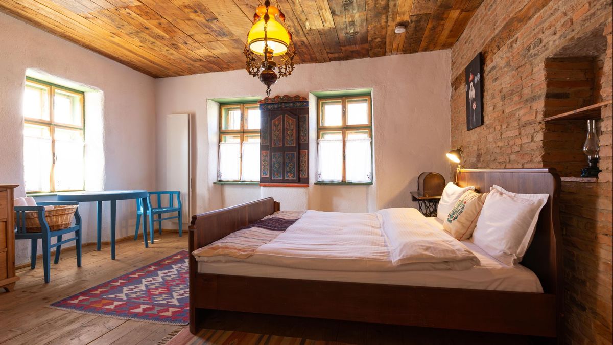 The room from the doorway, with the bed, windows and blue chairs