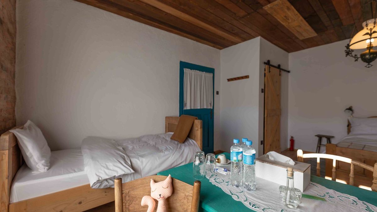 Single bed and the green table set for guests