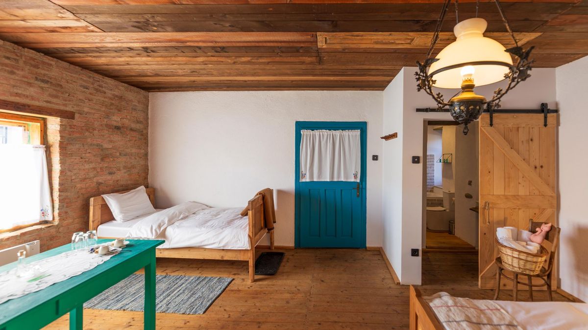 Both beds and the green table, seen from the bathroom door