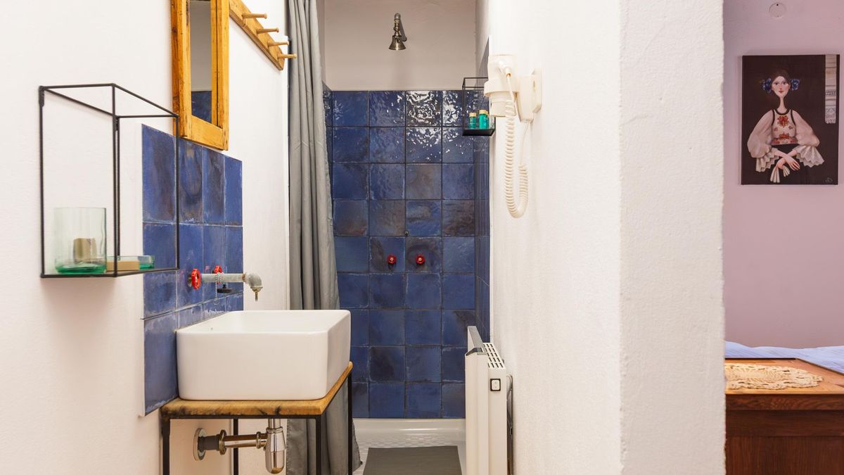 Shower in cobalt tiles and a washbasin on an oak stand