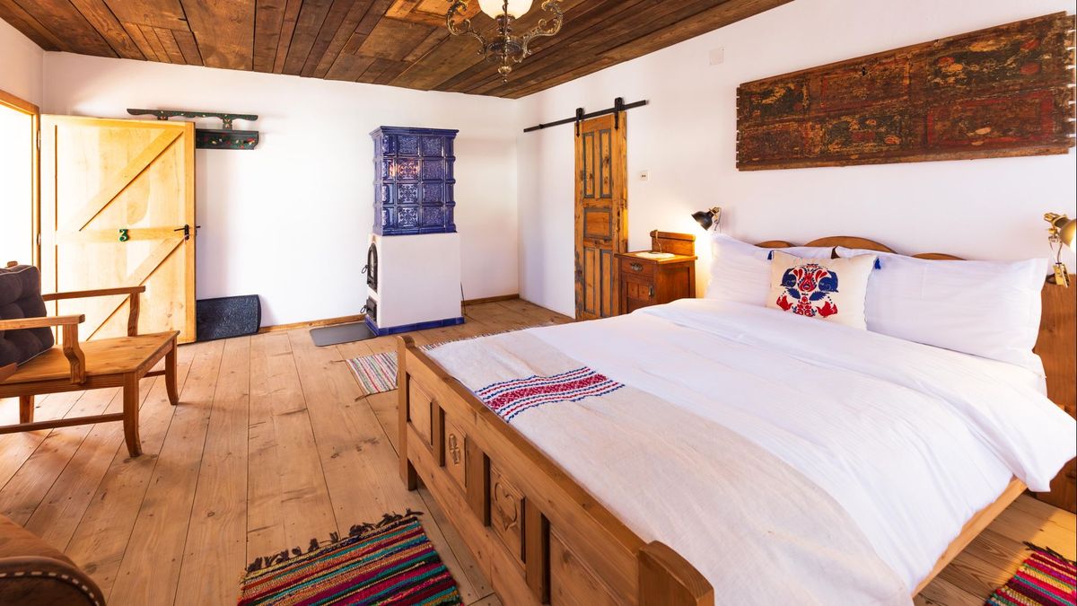 Double bed with an embroidered pillow and a carved panel above