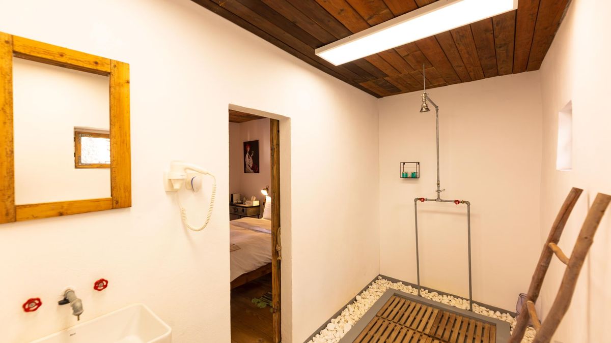 Bathroom with a pebble-floored shower and a wooden ladder