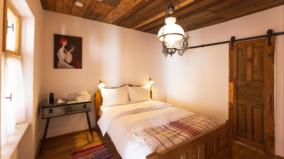 Bed, a painted portrait and the sliding plank door