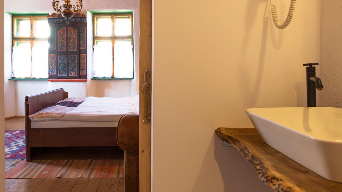 Washbasin on a live-edge oak slab, with the bed beyond